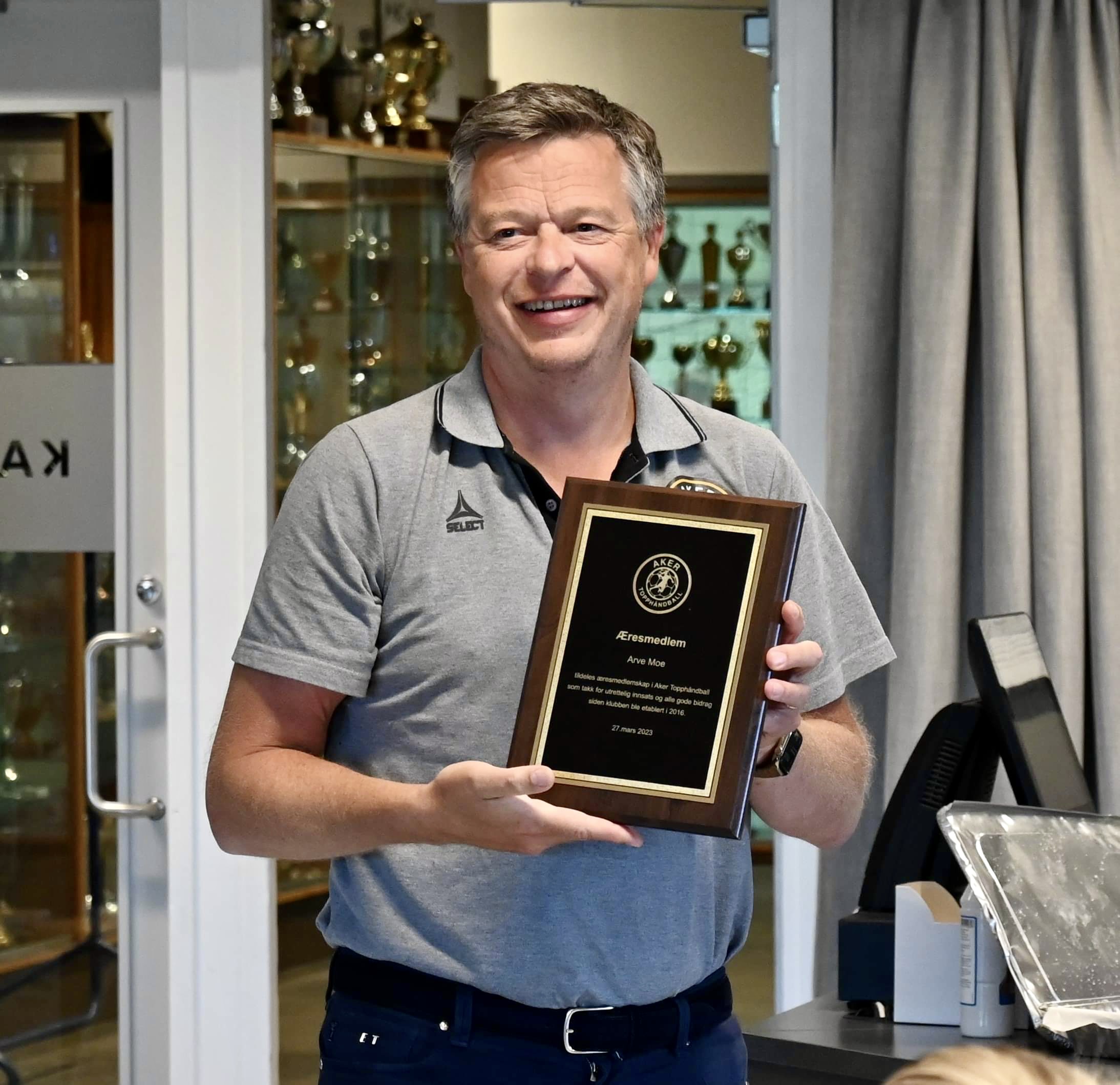 Tom Erik Myrland viser frem plaketten 